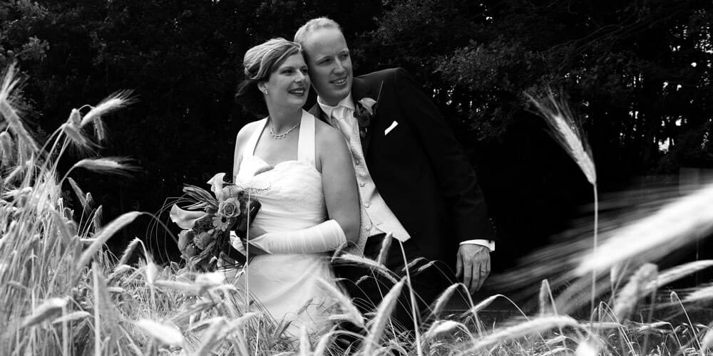Bruidspaar in hoog gras, zwart-wit